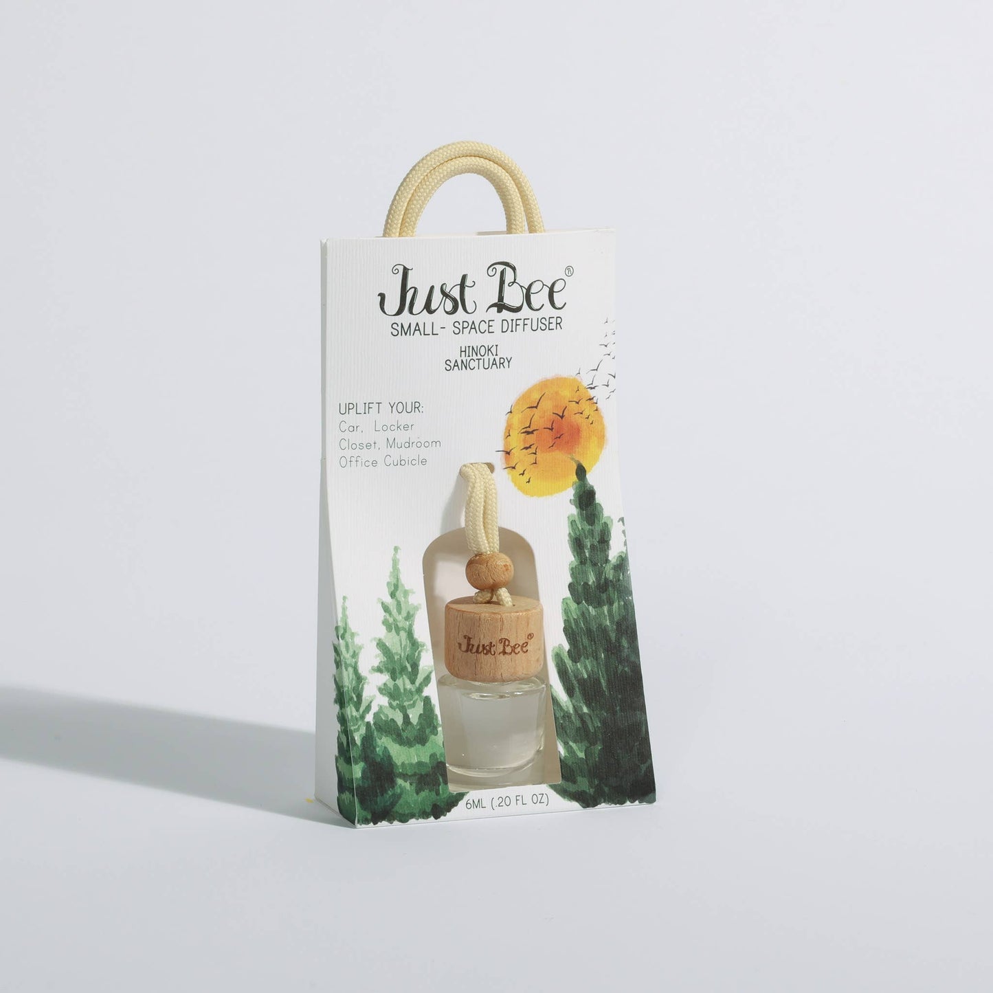 Small hanging glass diffuser with wooden cap in illustrated mountain forest packaging