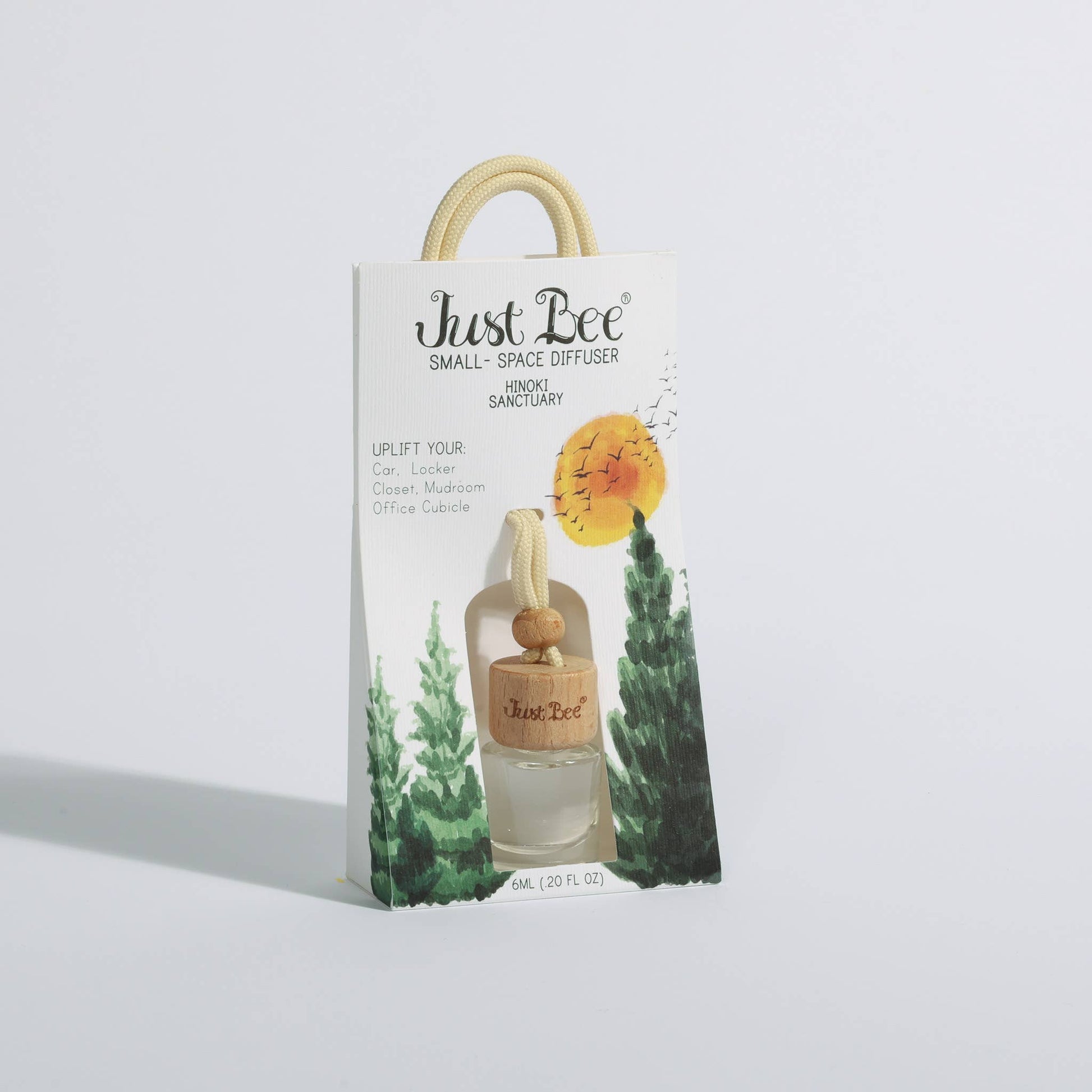 Small hanging glass diffuser with wooden cap in illustrated mountain forest packaging