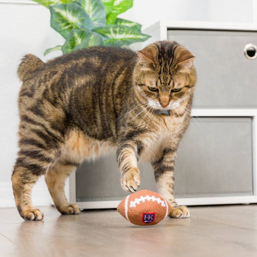 Brown plush football-shaped cat toy with white stitching and organic catnip.