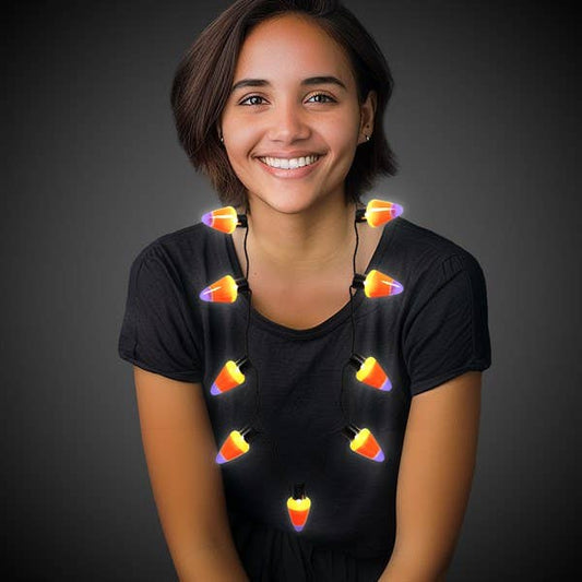 Woman wearing a glowing candy corn necklace with orange, yellow, and white lights