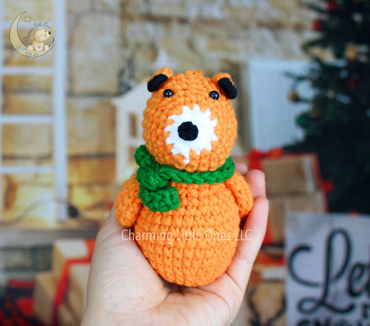 Crocheted orange fox Christmas ornament with black ears, white nose, and green scarf.