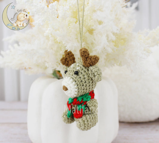 Crocheted reindeer ornament in green with brown antlers and a festive red scarf.