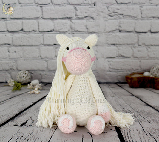 "Large handmade crochet horse with white body, pink details, and long flowing mane, perfect for decorating and cuddling."