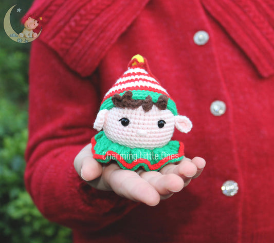 Cute crochet Christmas elf ornament with a striped hat, brown hair, and a green and red outfit.