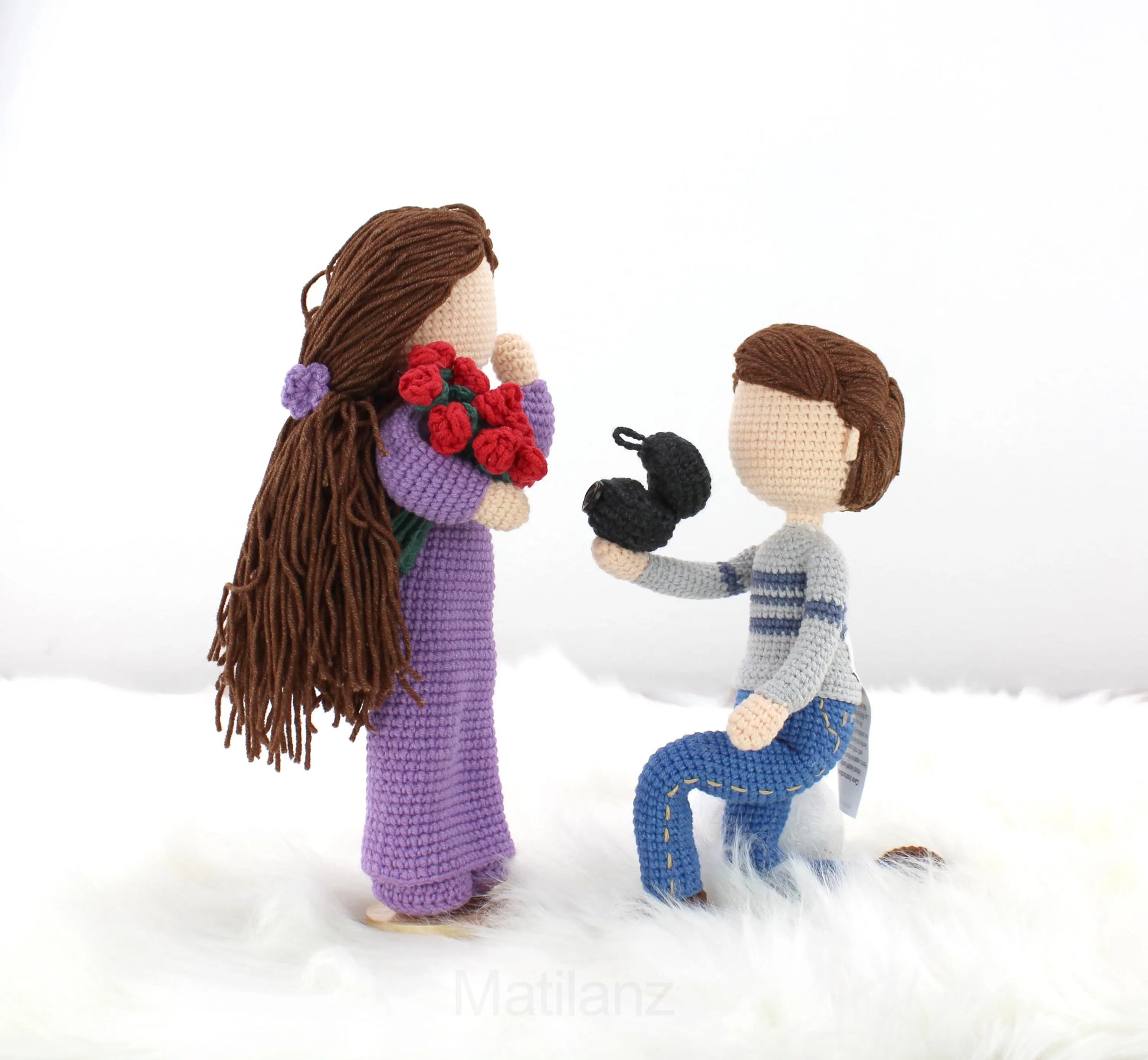 Crocheted dolls in a proposal scene, one holding flowers and the other kneeling, perfect for personalized gifts.