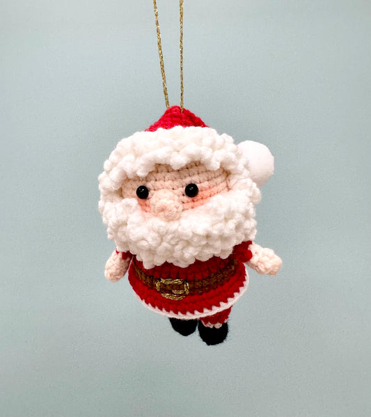 Crochet Santa Claus ornament with red suit, white beard, and gold belt, perfect for holiday decorating.