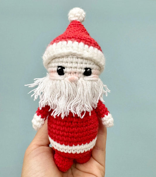 Handmade crochet Santa Claus ornament with a red and white outfit, fluffy white beard, and a cheerful expression.
