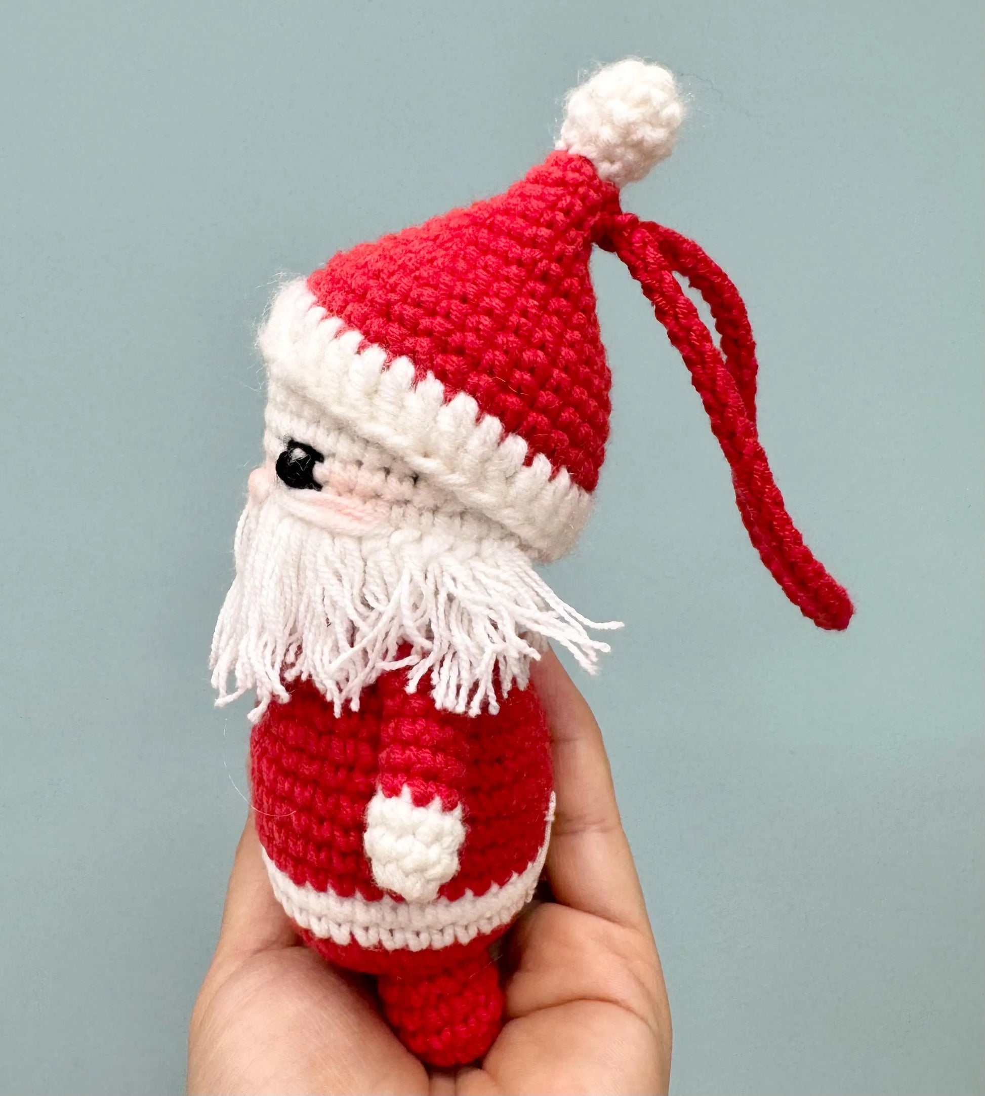 Handmade crochet Santa Claus ornament with a red hat, white beard, and festive red and white outfit.