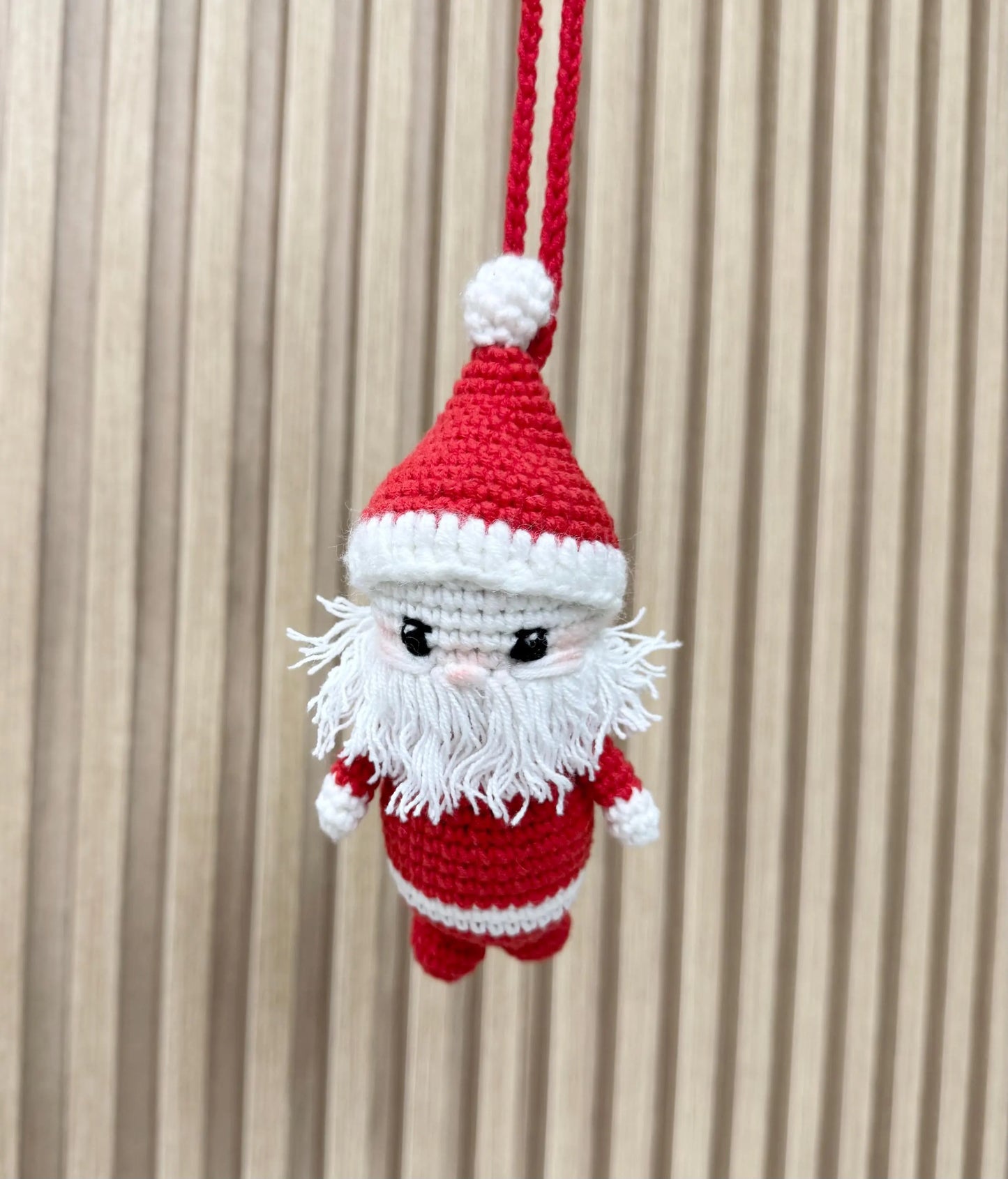 Handmade crochet Santa Claus ornament with a red and white outfit, fluffy white beard, and a festive hat.